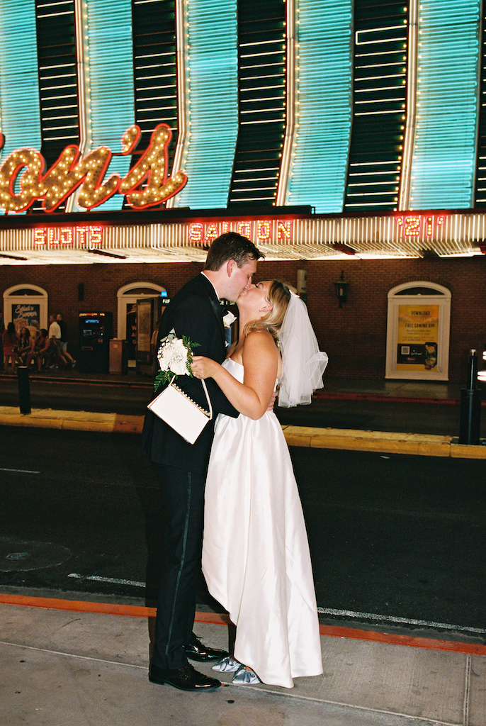 bride and groom kissing on street