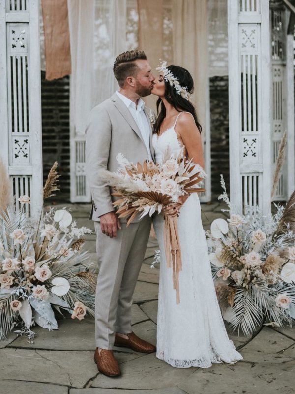 bride and groom kissing at their boho inspired wedding