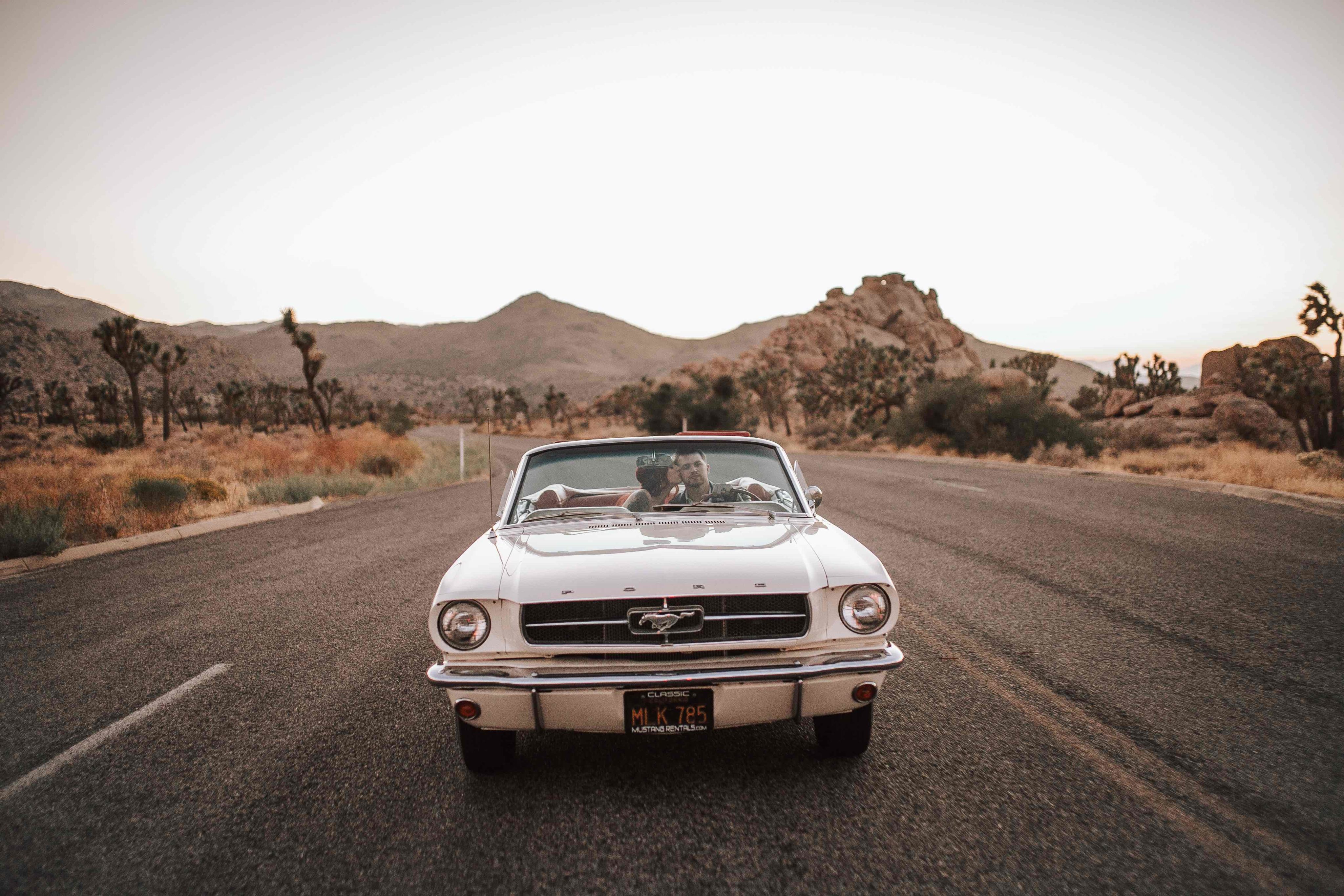 Jordan and Tylar in white Mustang at sunset