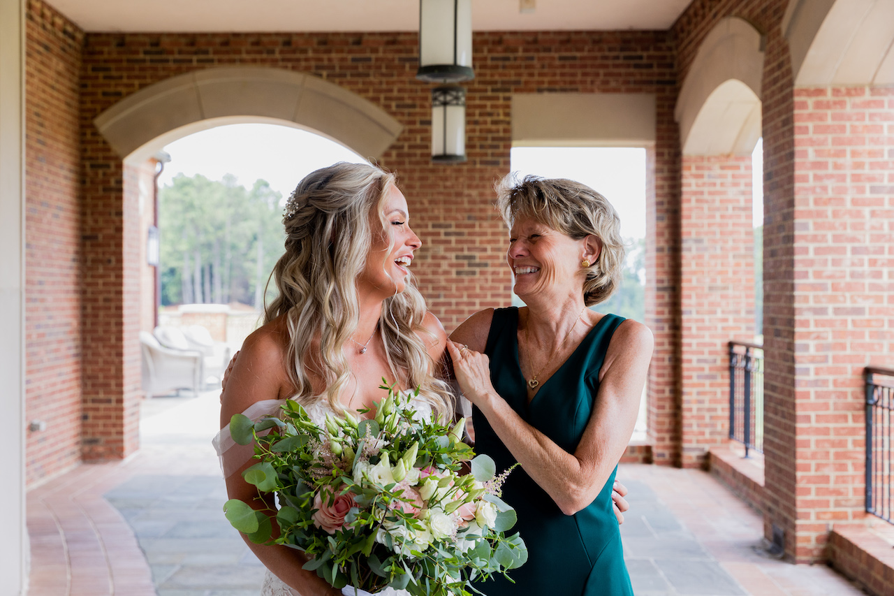 bride and mother of the bride laughing 