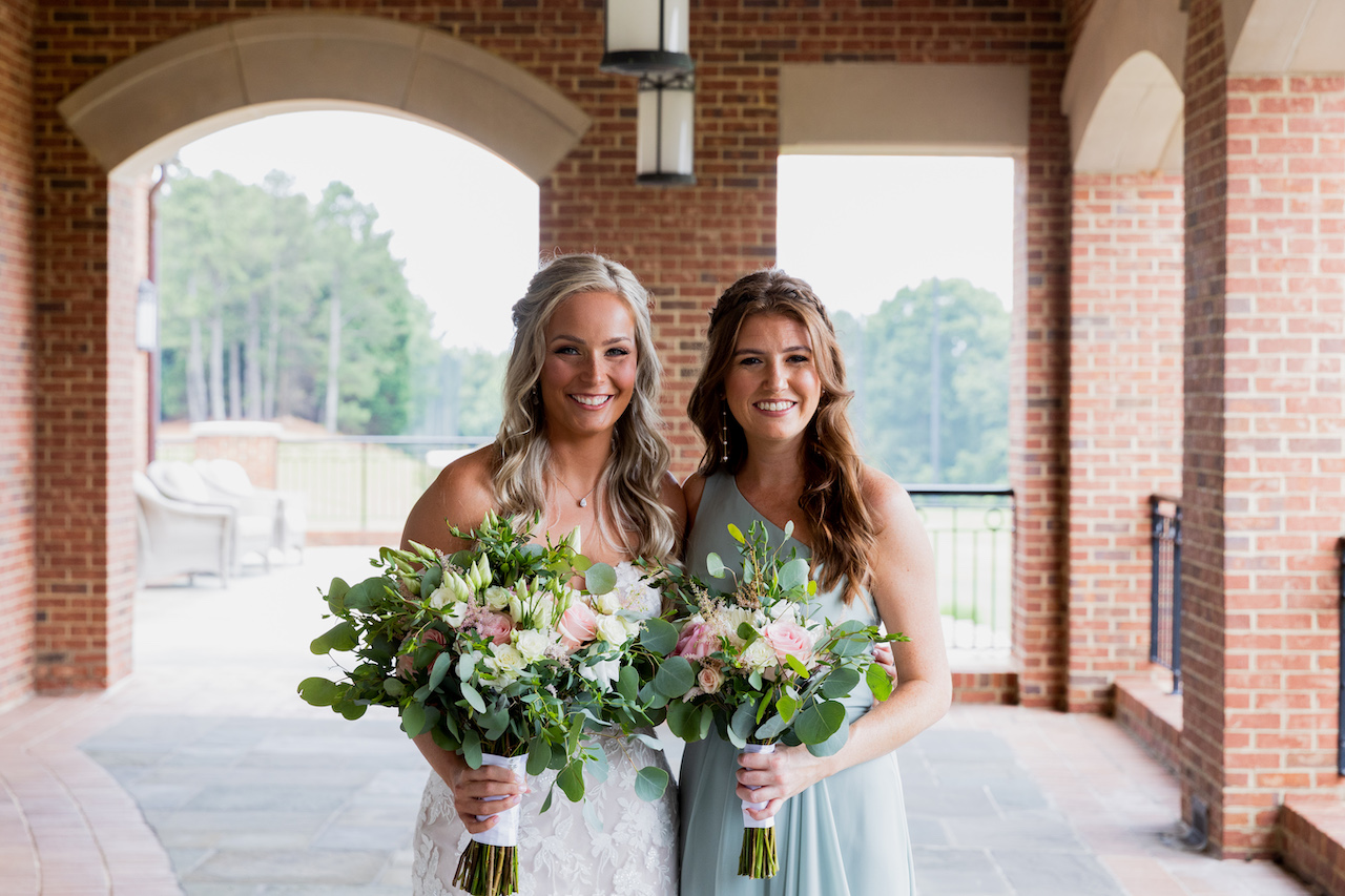 bride and bridesmaid smiling 