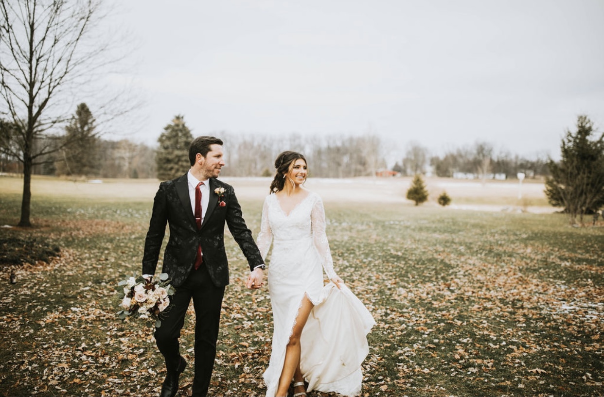 Bride and Groom holding hand in field
