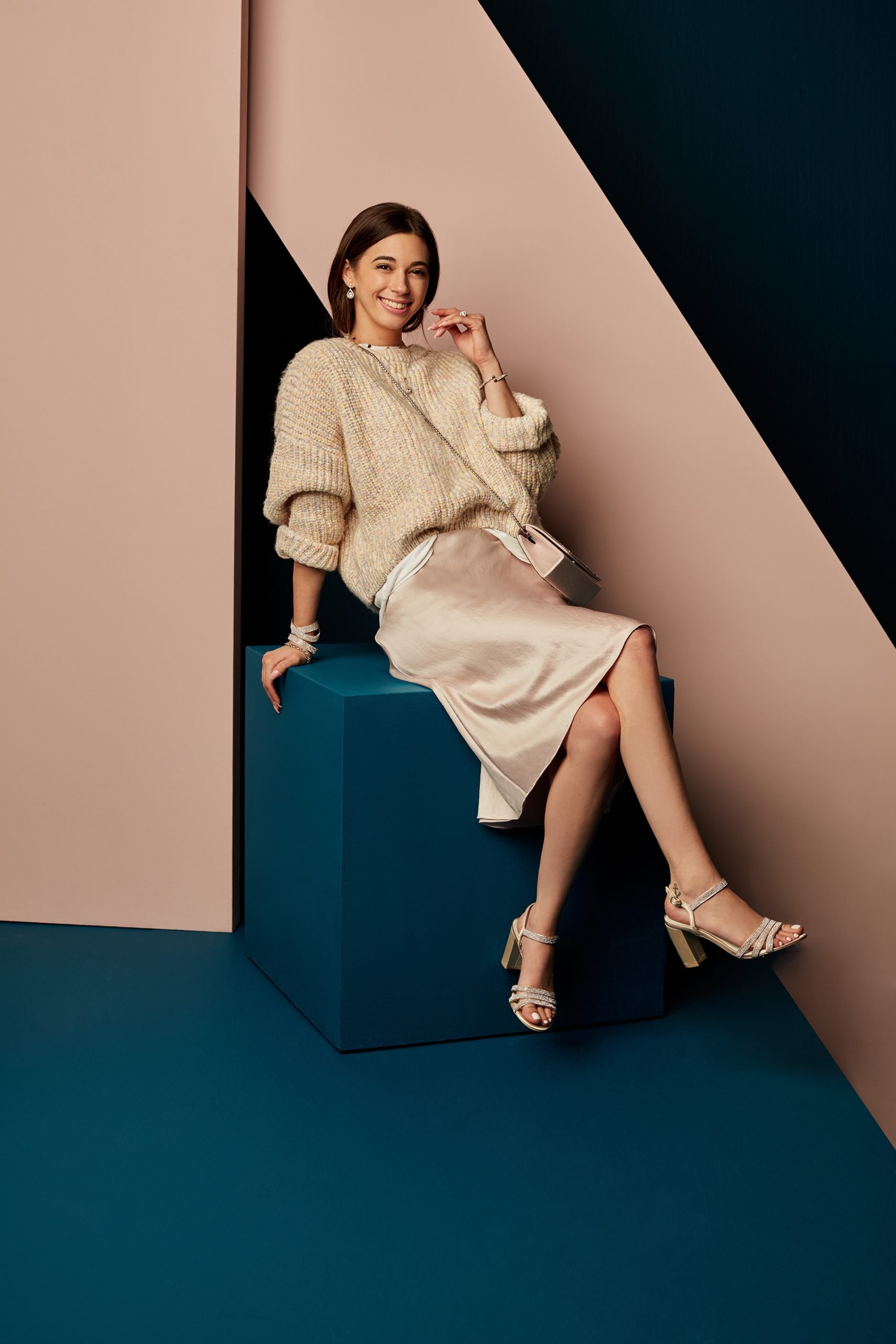 girl wearing gold satin slip dress with a chunky cardigan as a way to restyle a wedding day look