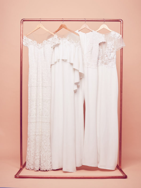 Bohemian wedding dresses hanging on a rack by Tadashi Shoji at David's Bridal