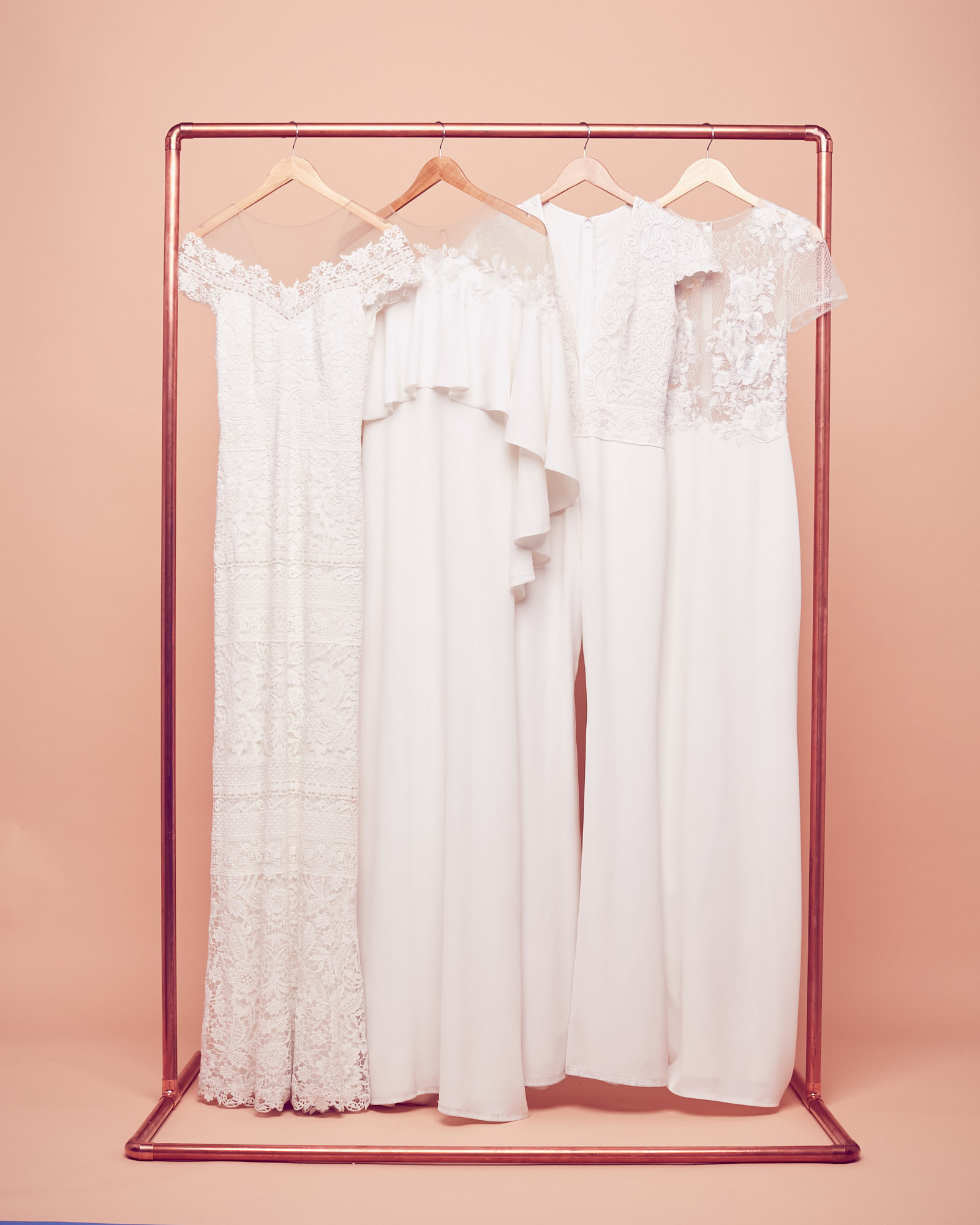 Bohemian wedding dresses hanging on a rack by Tadashi Shoji at David's Bridal